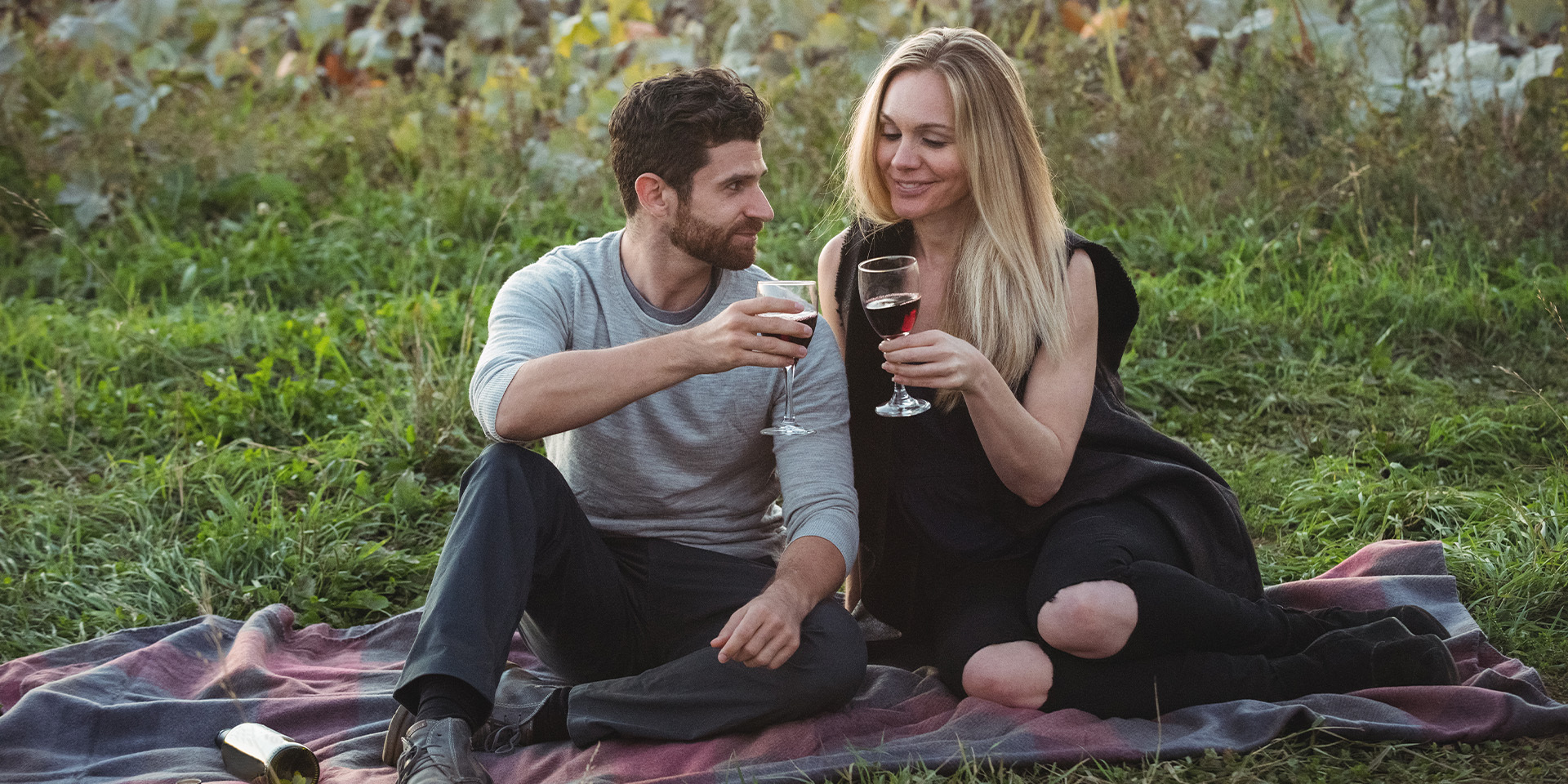 couple sitting outside together on blanket for a romantic picnic