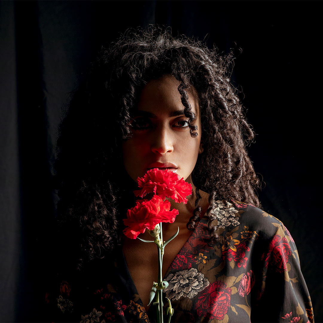 Romantic gothic headshot of woman holding a rose
